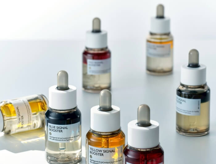カラーバリエーションのある複数の美容液ボトル。スポイト付きのスキンケア製品が並ぶ